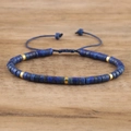 Detailed macro shot of blue imperial stone beads and gold cylinder spacers on woven cord - No.19 Lapis Lazuli