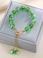 Adjustable green beaded bracelet with gold accents and drawstring tassel in a jewelry box - Green Iridescent Faceted Bead Bolo Bracelet (K-622)
