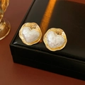 Vue macro de boucles d'oreilles cœur en or 16K avec texture en résine baroque - Aiguille en argent / Cœur (Plaqué Or) / Poche zippée