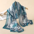 Floral print chiffon scarf in teal and emerald green hanging on a wooden hanger - Blue Green White Floral