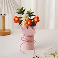Detailansicht handgefertigter Häkelblumenstrauß mit 5 Puffblumen in rosa Eimer - Feenblume / Orangefarbene Puffblume (Runder Eimer + Fenstertasche + Licht)