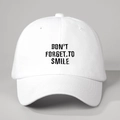 Dettaglio del berretto bianco in cotone con ricamo Don't Forget to Smile e visiera curva - Bianco