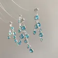 Macro detail of silver tassel earrings featuring blue resin stones and dangling chains - 8# Silver Earring Post - Blue - Round Tassel