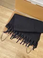 Thick black knitted mohair scarf with fringe trim displayed on a leather chair - Classic Black