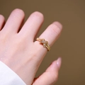 Überkreuzter 18K vergoldeter Ring mit Zirkonia-Steinen an der Hand getragen - Kreuzdesign (6975) / Gold