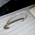 Macro detail of silver-colored pavé diamond bangle showing sparkling stones in a velvet box - Three-row Pave Setting (HB5074) / Silver