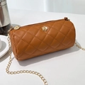 Brown quilted cylinder crossbody bag with gold floral accents and metal chain strap - Brown