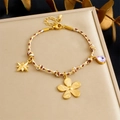Dettaglio del bracciale intrecciato con ciondoli a stella dorata e cristallo viola - Stile Stella Ottagonale Fiore Cristallo Viola (B1818)