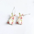 Detail of floral Easter bunny earrings with white fuzzy pom-pom tails on white background - Pink Green Floral