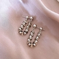 Minimalist silver triangle beaded U-shaped earrings on elegant pink satin background - Triangle Spliced / Silver