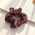 Retro dark red plaid scrunchie for ponytails placed on an open book for aesthetic style - JK Shahua