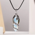 Vue détaillée du pendentif dragon argenté entourant un cristal d'opalite hexagonal - Opale
