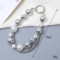 Detail van 13 cm lange telefoonhanger met parels en strass en zilveren metalen ring - Strass Bal Stijl