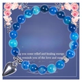 Detailed macro view of 8mm blue agate beads with a silver heart pendant on a gift card - Blue (Style 3)