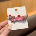 Detail of dachshund hair clip with pink sweater and apple motif on brand card - Pink and Brown Plaid (Pink Plaid Sweater)