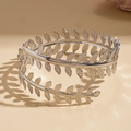 Detail of silver leaf arm cuff with delicate openwork foliage and artistic lighting - Arm Cuff / Silver