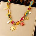 Bunte Seidenband-Halskette mit goldenem Herz- und Sonnenanhänger auf einer beigen Box - Rot Gelb Blau Seestern Kreuz Stil (N3626)