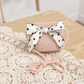 Detail of pink straw crossbody bag featuring a large polka dot bow on a lace mat - Pink Bag