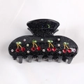 Glittery black claw clip with red rhinestone cherry pattern on white fabric background - Glitter Black