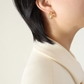 Orecchini a cerchio dorati vintage con zirconi scintillanti indossati da una modella - Oro Zirconia Bianca