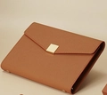 Vue détaillée du carnet en cuir marron avec une texture grainée et un fermoir doré carré - 32K / café