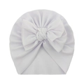 Detail of white waffle knit baby turban hat featuring a large decorative bow - White