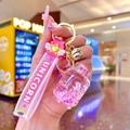 Close-up of pink unicorn quicksand keychain with UNICORN strap and golden bell charm - Pink Luminous Bubble Bead Gas Tank