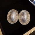 Primer plano de pendientes de perlas blancas ovales con bordes de metal plateado - Plateado