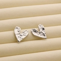 Irregular heart stud earrings in silver finish with a unique hammered metal texture - R191 Wavy Heart / Steel