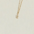 Golden necklace featuring a letter E pendant adorned with white pearls on a bead chain - Letter E