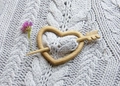 Detail of a heart-shaped wooden brooch pin with arrow fastener on a knitted sweater - Heart
