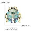 Goldene Käfer-Brosche mit grünem Emaille und hellblauen Kristallen, 3 cm mal 2,9 cm groß - Blau
