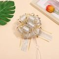 Macro shot of a decorative gold ribbon bow with metallic edges for gift wrapping - White