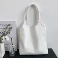 Detailed texture of thick white canvas tote bag with reinforced stitching and blank surface - White