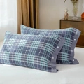 Pair of blue and light green plaid cotton pillowcases with snap buttons on white sheets - Blue Plaid