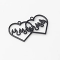 Detail of two black heart-shaped hollow charms with flame patterns for DIY jewelry - Black