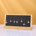 Minimalist gold necklaces with heart and pearl pendants on a bamboo display stand - Black / PU Leather