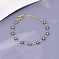 Vista macro dettagliata di un bracciale a catena dorato con margherite in smalto blu e giallo - Blu - Oro