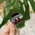 Close-up of a tortoiseshell acetate hair claw clip with a glossy finish and smooth teeth - Matte Reddish Brown
