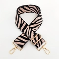 Macro detail of zebra print bag strap with pink base and polished gold metal hooks - Light Pink Zebra Print / Gold Buckle