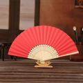 Red folding paper fan with hollowed wooden ribs on stand for DIY painting - Red