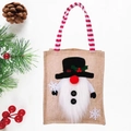 Linen Christmas gift bag featuring a snowman design and red striped handle on wood background - Snowman Gift Tote Bag