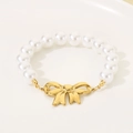 Close-up of elegant gold bow and white imitation pearls on a stylish summer bracelet - Bow Pearl Style (KB203119-SXSJ)