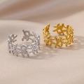Detail view of silver and gold open rings featuring olive leaf design on fabric background - Olive Leaf