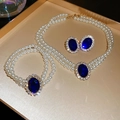 Dettaglio macro del set di gioielli di perle con pietre blu ovali e accenti di cristallo - Blu (Set da 3 pezzi)