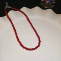 Collier de perles rouge foncé avec fermoir mousqueton argent sur plateau ondulé - Collier-Fermoir Argenté-Rouge-Diamètre 6mm