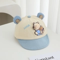 Detail of baby cap featuring 3D bear backpack patch and Luck embroidery in soft blue - 48cm (6 Months-2 Years) / Blue