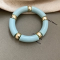 Dettaglio di perline in acrilico azzurro e distanziatori in metallo dorato sul bracciale - Azzurro
