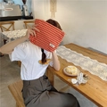 Close-up of red and white checkered jacquard makeup bag held by a person in a cafe - Red Plaid Jacquard