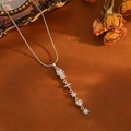 Detail of silver multi-charm necklace with Fatima hand and cross pendant on retro background - Silver Tassel Hamsa Style (T001)